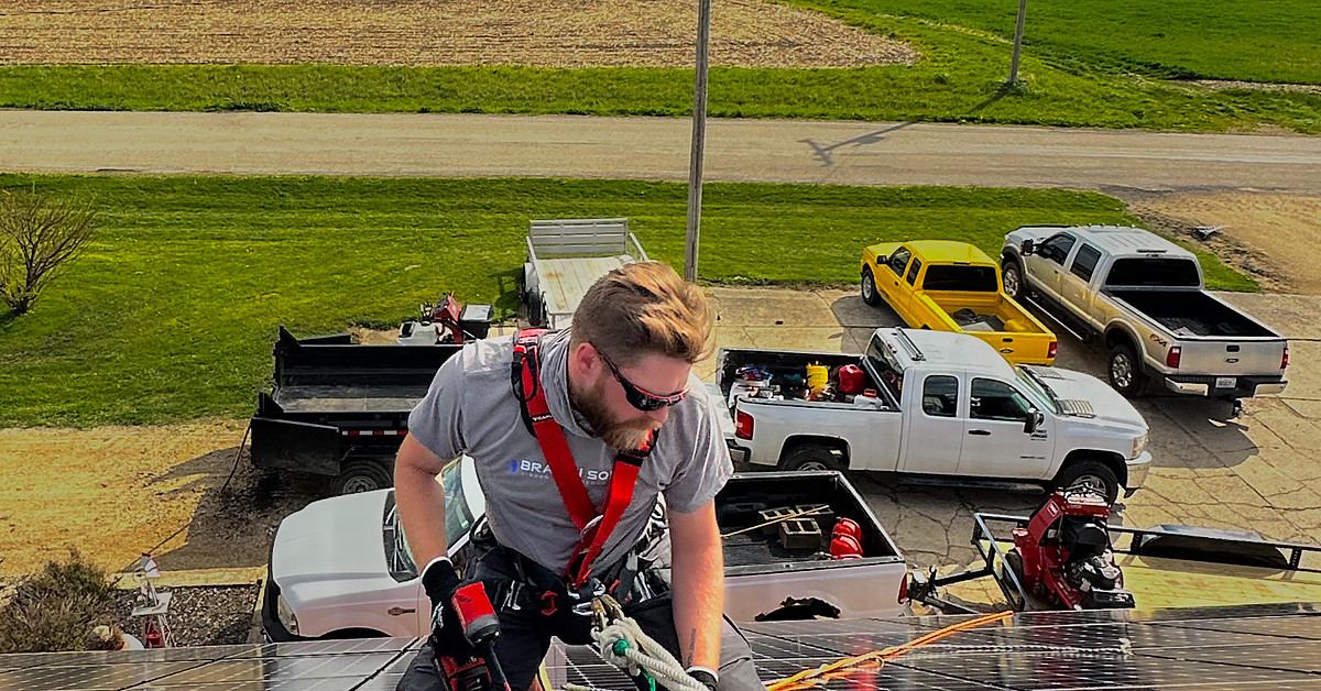 Braven installer working on a metal shed roof array at a farm