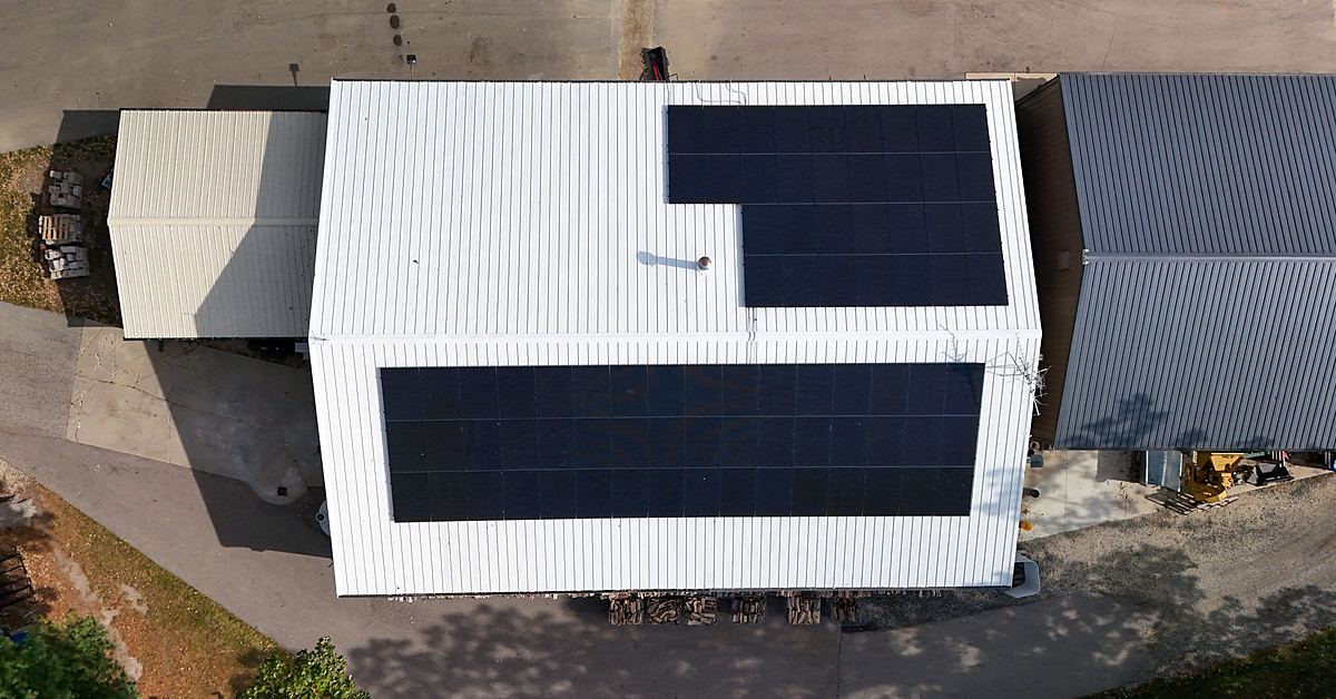 Top-down view of the Boone County farm's two solar arrays on a white metal barn roof