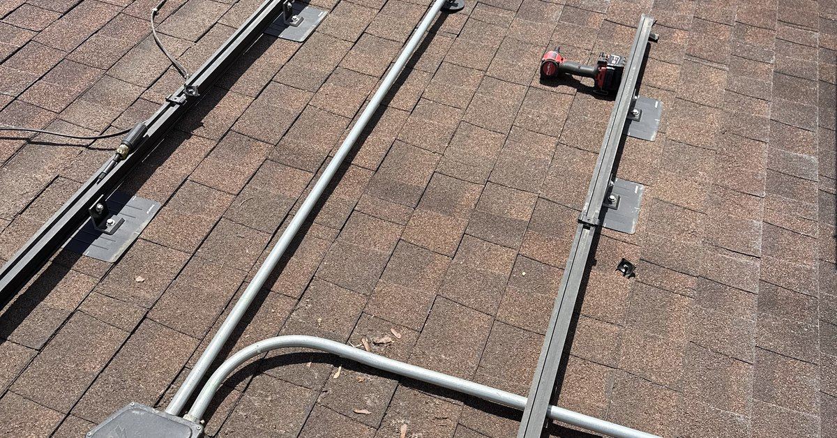 Rails and conduit set on a roof mid-way through a solar reinstall