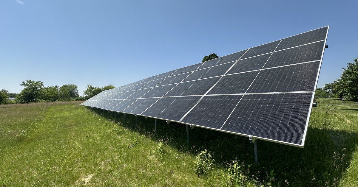 Ground-mounted solar array row seen end-on