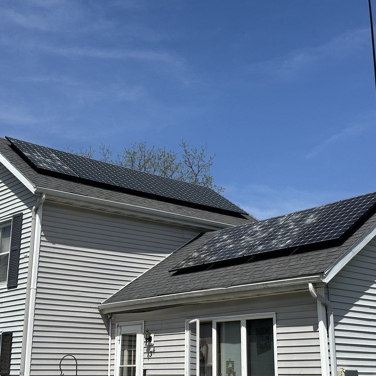 Street view of a home's rooftop solar array after a hail storm