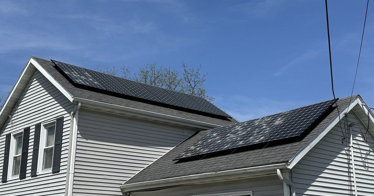Street view of a home's rooftop solar array after a hail storm