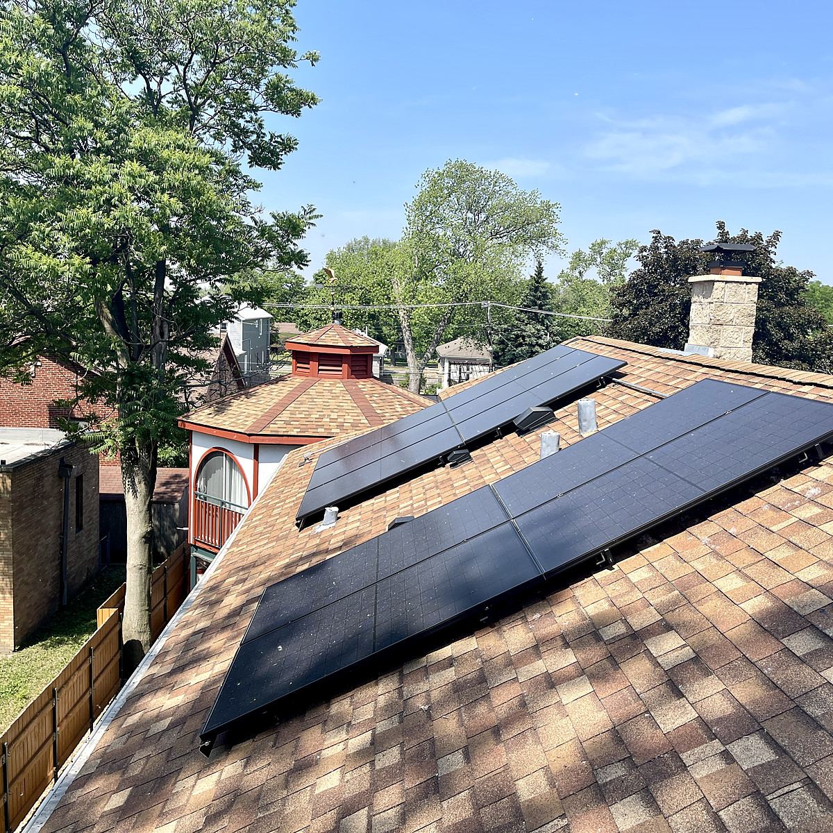 Rooftop solar array beside a brick chimney on a Northern Illinois home