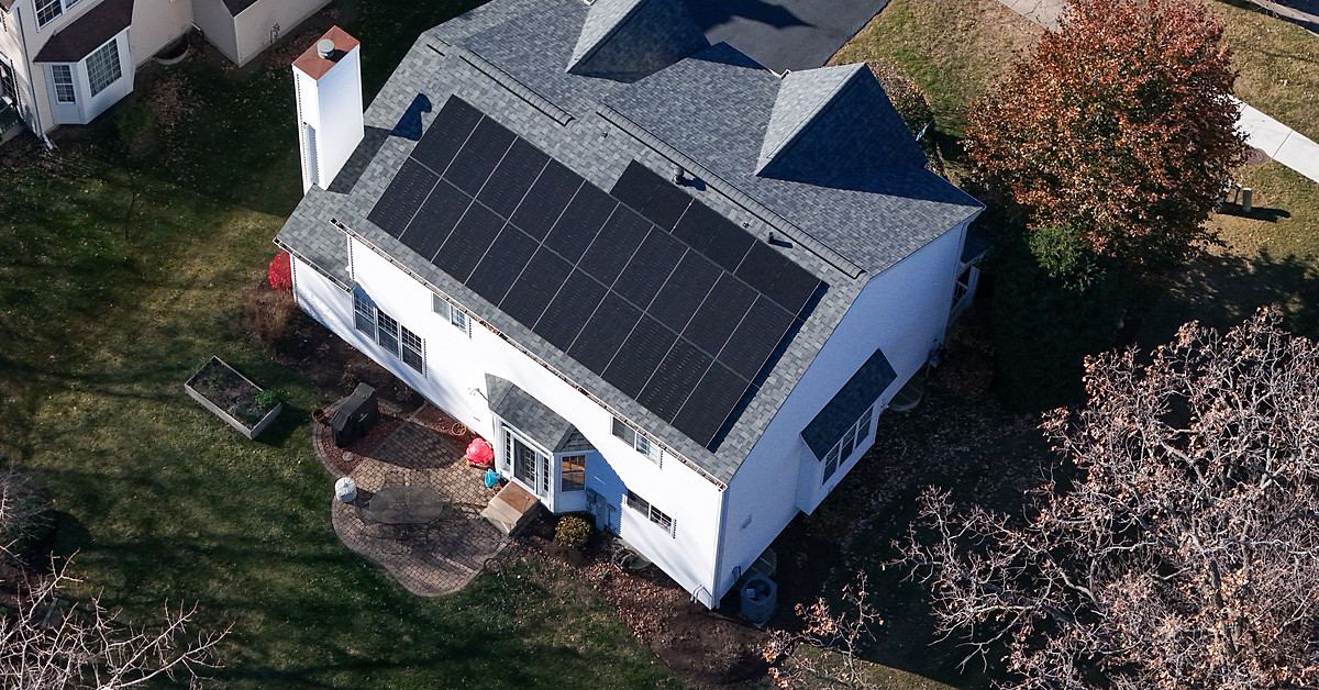 Aerial view of a home with a full-roof solar array