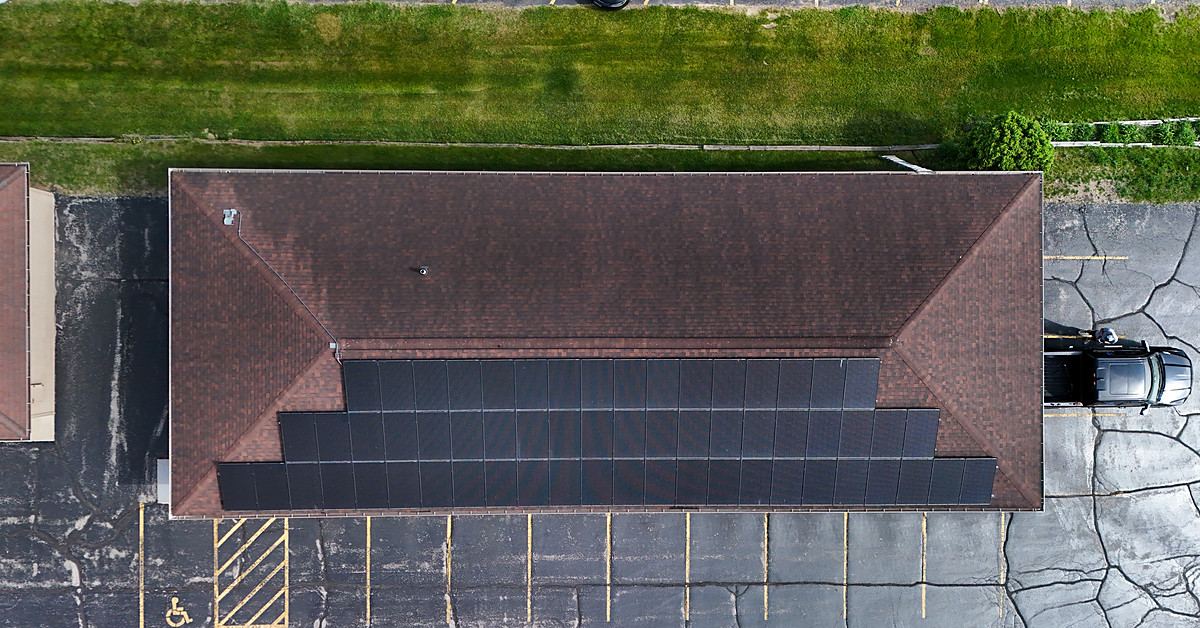 Aerial view of a long rooftop solar array on a single-storey commercial building