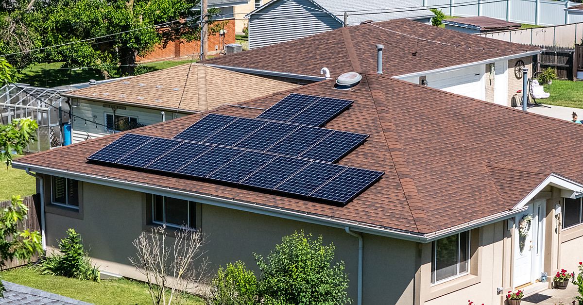 Aerial view of a Braven Solar rooftop array on a ranch home surrounded by mature trees in Northern Illinois
