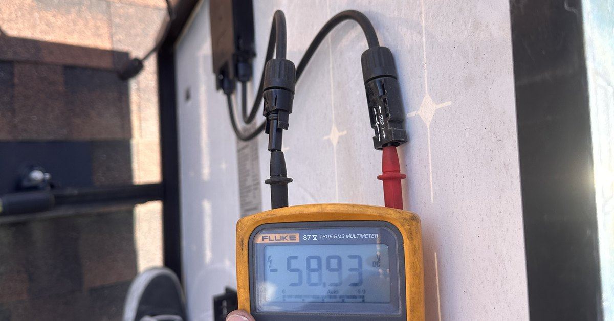 A Fluke multimeter reading DC voltage at a solar module's leads
