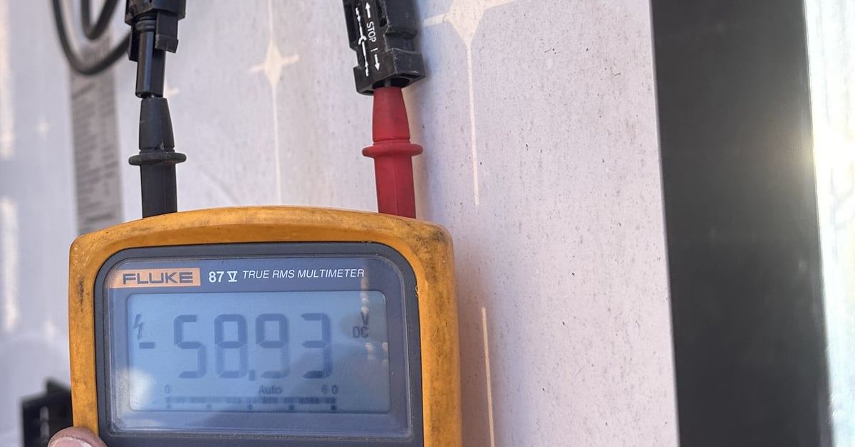 A Fluke multimeter reading DC voltage at a solar module's leads